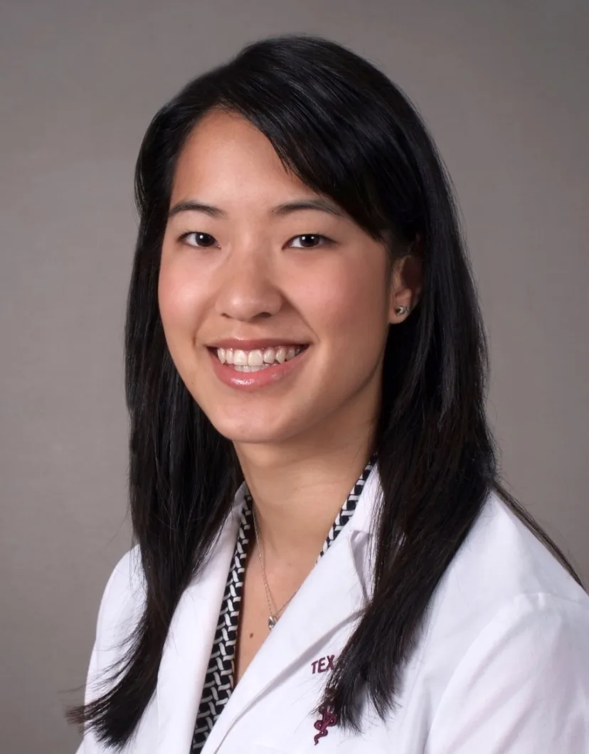 A professional portrait of Dr. Joyce Li smiling with a gray background